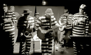 Black and white of a group of men in serene prison uniforms